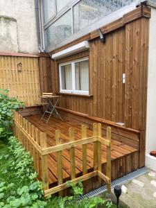 eine Holzterrasse mit einem Fenster und einem Gebäude in der Unterkunft Eiffel Tour Cosy Jade in Paris + 2 Fotos