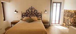 a bedroom with a large bed and a stone wall at Casita con jardin en Sada in San Andrés de Carnoedo