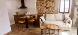 a living room with a couch and a table with stools at Casita con jardin en Sada in San Andrés de Carnoedo