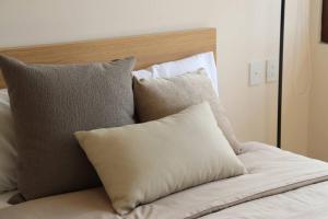 a pile of pillows sitting on top of a bed at Departamento acogedor con vista al mar y alberca in Conchal +49 photos