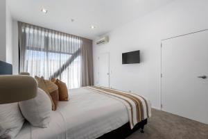 基督城Southwark Hotel & Apartments的卧室配有一张大白色床和窗户