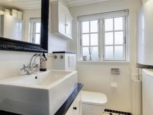 a bathroom with a sink and a toilet and a mirror at 4 person holiday home in Karrebæksminde in Karrebæksminde +42 photos