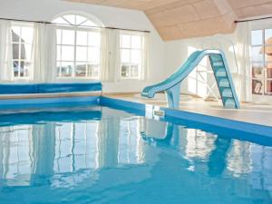 a swimming pool with a slide in the water at Luxury Pool House near Sea - By Traum Ferienwohnungen in Harboør