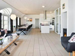 a living room with a table and a kitchen at Luxury Retreat by the Sea - By Traum Ferienwohnungen in Ulfborg