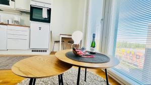 a table with a hat and a bottle of wine at Cozy studio apartment 6 mins by Train to Airport in Vantaa +7 photos
