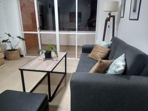un soggiorno con un divano blu e un tavolo di Departamento centrico en Resistencia a Resistencia