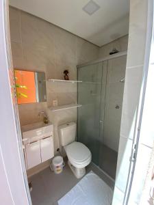 a bathroom with a toilet and a glass shower at Casa Sagrada 282 in Fortaleza