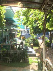 a patio with a table and benches in a garden at SlowLife Kohlarn in Ko Larn