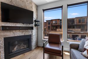 Una sala de estar con chimenea y TV de pantalla plana. en Blue River Flats Bld 3 203 By Summit County Mountain Retreats, en Silverthorne