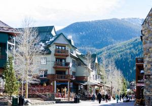 un edificio en una calle con una montaña en el fondo en Blue River Flats Bld 3 203 By Summit County Mountain Retreats, en Silverthorne