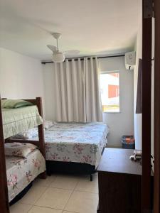 a bedroom with two beds and a window at Cond Praia Da Perola - Apt Rosa 7 in Ilhéus