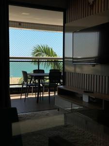 a dining room with a table and a view of the ocean at landscap Meireles Fortaleza in Fortaleza