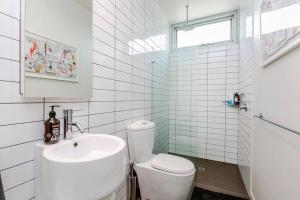 a white bathroom with a sink and a toilet at Ripple at Port Willunga in Port Willunga +24 photos