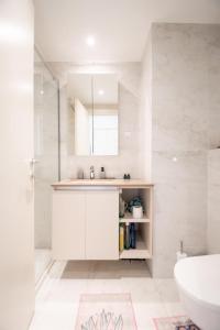 a white bathroom with a sink and a mirror at Belgrade Waterfront Nimax in Sajmište