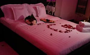 a pink bed with a bunch of food on it at Regim Relax 2 in Bucharest +7 photos