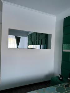 a living room with a mirror and green accents at Regim Relax 2 in Bucharest