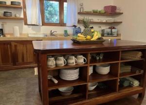 a kitchen counter with a island with a bowl of fruit at Jim's Beach House in Playa Grande +16 photos