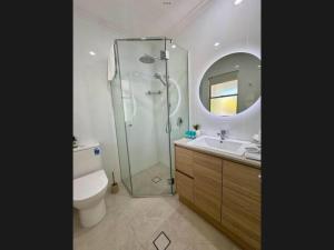 a bathroom with a shower and a toilet and a sink at Reef Terraces on St Crispins in Port Douglas +6 photos