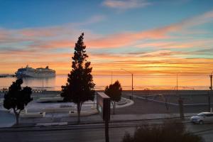 a cruise ship in the water with a sunset at Departamento Céntrico Frente al Mar y con Cochera in Puerto Madryn