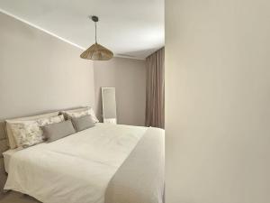 ein Schlafzimmer mit einem weißen Bett und einer Hängeleuchte in der Unterkunft Crystal Luxury Holidays, El Palm Mar in Tenerife South in Palm-mar + 49 Fotos