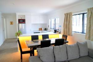 sala de estar y cocina con mesa y sofá en Large Group Greymouth accommodation 2 houses with 7 bedrooms 6 queens 6 single beds 5 bathrooms 5 toilets, en Greymouth
