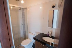 a bathroom with a toilet and a sink and a shower at Relajate en Moderno y Elegante Apartamento Familiar con amplio balcón, en Zona Residencial Avenida Beni in Hamacas +20 photos