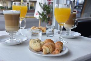 a table with three glasses of orange juice and croissants at PASTORA Suites & Hostel - Punta del este in Punta del Este