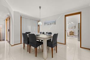 a dining room with a table and chairs at Colloden Beach House by Experience Jervis Bay in Vincentia