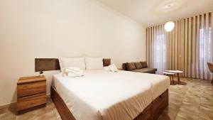 a bedroom with a large white bed and a couch at Rooms4you 2 in historic center of Braga in Braga