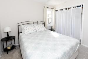 a white bedroom with a large bed and a window at Bluebirds Road to Happiness in Vermilion