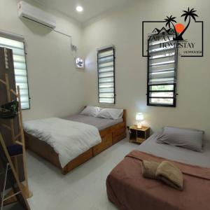 zwei Betten in einem Zimmer mit zwei Fenstern in der Unterkunft Zaifaa Homestay Pantai Penarik 4 Bilik,2 Bilik Air Dekat Jeti Ke Pulau Redang in Kampong Ru Sepuloh