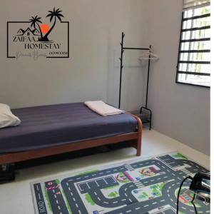 ein Schlafzimmer mit einem Bett und einem Teppich auf dem Boden in der Unterkunft Zaifaa Homestay Pantai Penarik 4 Bilik,2 Bilik Air Dekat Jeti Ke Pulau Redang in Kampong Ru Sepuloh