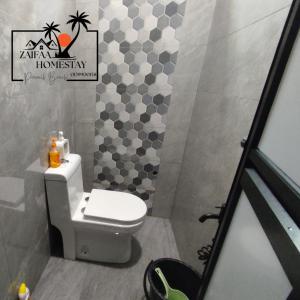 ein Bad mit einem WC und einer Fliesenwand in der Unterkunft Zaifaa Homestay Pantai Penarik 4 Bilik,2 Bilik Air Dekat Jeti Ke Pulau Redang in Kampong Ru Sepuloh