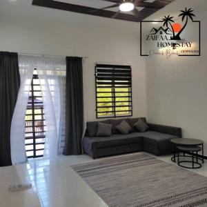 ein Wohnzimmer mit Sofa und Tisch in der Unterkunft Zaifaa Homestay Pantai Penarik 4 Bilik,2 Bilik Air Dekat Jeti Ke Pulau Redang in Kampong Ru Sepuloh