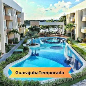 a swimming pool in the middle of a building at Guarajuba Porto Smeralda Village C02, térreo - GUARAJUBA TEMPORADA, viva mais de uma experiência de hospedagem conosco! 130m da praia in Guarajuba