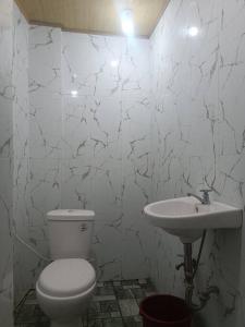 a white bathroom with a toilet and a sink at CM Heights Homey 2 bedrooms in General Santos