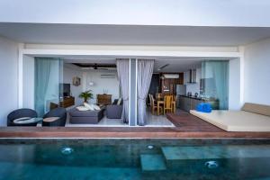 a living room and kitchen with a swimming pool at Aqua Samui 204- Included airport pickup in Ban Ko Khwan