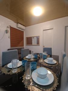 a dining room table with plates and glasses on it at CM Heights Homey 2 bedrooms in General Santos