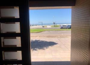 a view of a parking lot through a window at AP beira mar perto do centro in Capão da Canoa