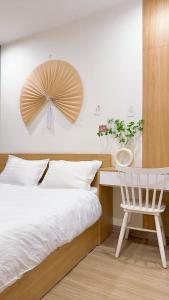 une chambre avec un lit, un bureau et une chaise dans l'établissement AnChi Home - Garden view- Căn hộ 2 giường đẹp - Ocean Park Gia Lâm, à Hanoï