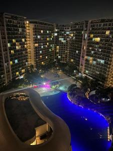 a view of a swimming pool at night with buildings at The Bahamas & Maldives Suites at Azure Residences near Manila Airport in Manila