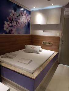 a bed in a room with a painting on the wall at motel chanty in Piracicaba