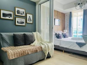 a living room with a couch and a bed at The Bahamas & Maldives Suites at Azure Residences near Manila Airport in Manila