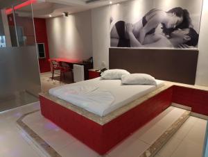 a bed in a room with a picture on the wall at motel chanty in Piracicaba