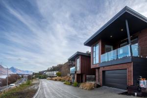 una casa en una colina con un garaje en Stylish 2-BR Home, Scenic Balcony, Key Amenities, en Queenstown