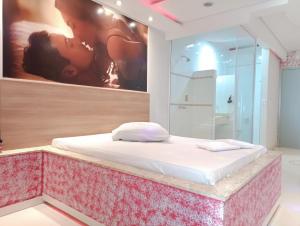a bed in a room with a painting on the wall at motel chanty in Piracicaba +16 photos