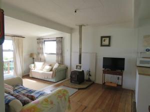 a living room with a couch and a television at Rustic Charmer in Cable Bay in Cable Bay