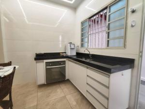 a kitchen with a counter top and a sink at Casa para descanso e tranquilidade in Uberaba