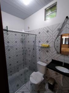 a bathroom with a shower and a toilet and a sink at Chalé Marinas in Barreirinhas