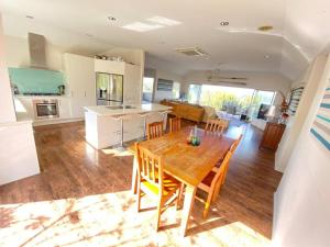 a kitchen and dining room with a wooden table and chairs at Russell's Secluded Secret in Russell